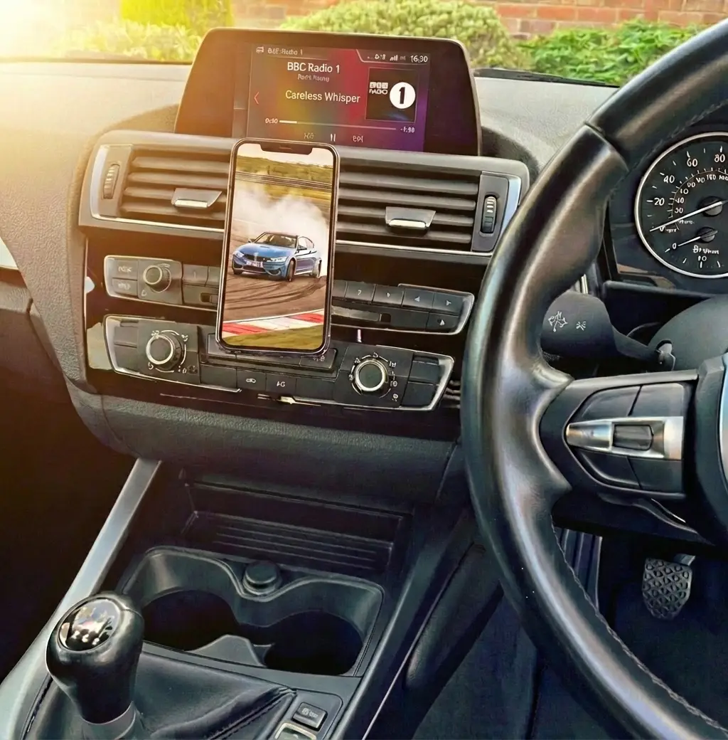 Custom magnetic CD slot phone holder in a BMW F-Chassis interior, holding a smartphone displaying a drifting BMW M4.